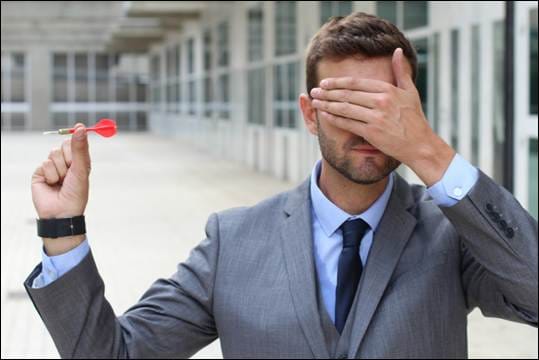 A person in a suit holding a dart in his hand
AI-generated content may be incorrect.